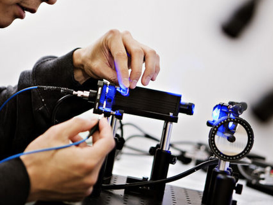 Albert Tsao examines a laser used by researchers to send light pulses along an optical fibre into their study subjects’ brains. (Photo: Geir Mogen, NTNU)