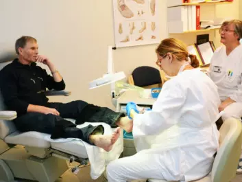 Foot therapist Ingeleiv Rafdal Falkeid treats Ammund Vestbøstad’s feet. At right is Olaug Beathe Wiig, a nurse who specialises in diabetes treatment at the Stavanger University Hospital’s Section of Endocrinology. (Photo: Linn Herredsvela)