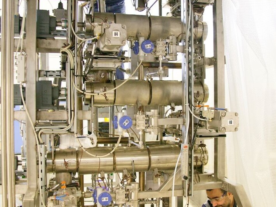 Senior engineer Willy Georg Horrigmo tips a bucketful of chopped-up branches and tops into the top of the laboratory reactor, while research scientist Roger Khalil waits for the results to emerge at the bottom of the processing equipment. It is a long route for the raw material, but on the other hand, it is transformed from low-value to high-value biofuel on the way. (Photo: SINTEF / Gry Karin Stimo)