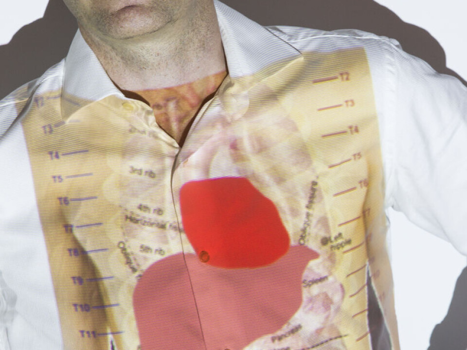 SINTEF ICT is planning to supervise patients with liver problems and monitor them at home. Scientist Frode Strisland has liver and heart projected on his body. (Photo: Werner Juvik/SINTEF)