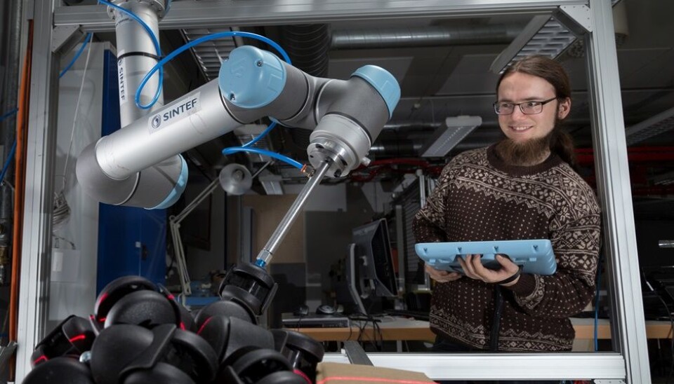 Researcher Sigurd Albrektsen is sitting at a PC that calibrates the settings of two robotic arms and a box of castors. (Photo: SINTEF /Thor Nielsen)