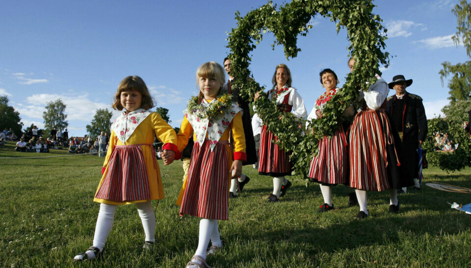 Local residents in traditional costumes carry a heart-shaped wreath as they arrive at the Midsummer celebrations in the Swedish town of Leksand. The annual event in Leksand is the largest midsummer festival in Sweden. (Photo: Bob Strong/Reuters)