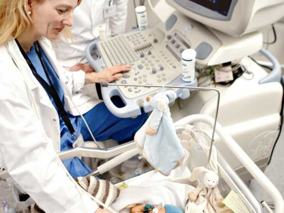 The image on the screen tells Lasse Løvstakken and Siri Ann Nyrnes the condition of this tiny newborn’s heart. (Photo: Geir Mogen/NTNU)