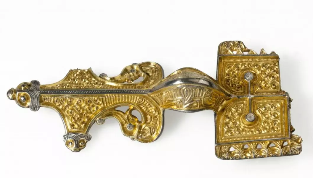 This gilded silver brooch, designed to clasp at the neck, is not quite the same as other Iron Age brooches found in the Skien area of Norway. The edging around the rectangular plate is typical, but the spiral decoration in relief shows that the craftsman was inspired by Danish and Swedish brooches. (Photo: Mårten Teigen, Museum of Cultural History, University of Oslo)