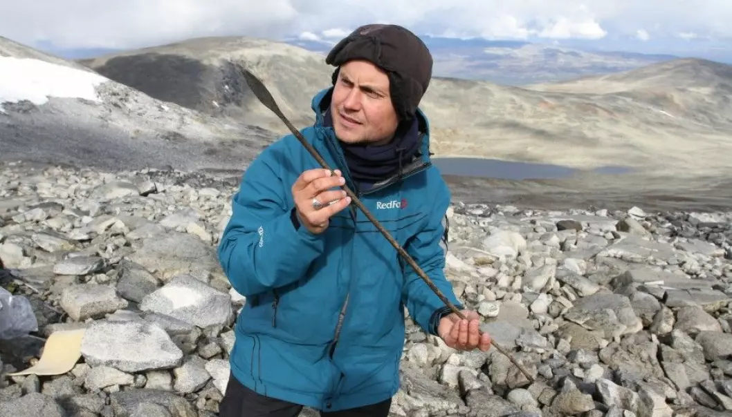 An archaeologist holds up an arrow, circa 1,400 years old, which was lost in a reindeer hunt in the mountains of Norway’s Oppland County during the Late Antique Little Ice Age. (Photo: Julian Martinsen, secretsoftheice.com/Oppland County)