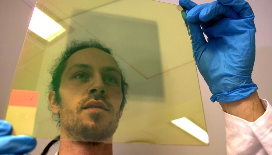 Researcher Trygve Mongstad studying a glass plate coated with a thin layer of vaporised metal hydride, a chemical compound consisting of yttrium and hydrogen, which darkens when struck by light. (Photo: Arnfinn Christensen) Researcher Trygve Mongstad studying a glass plate coated with a thin layer of vaporised metal hydride, a chemical compound consisting of yttrium and hydrogen, which darkens when struck by light. (Photo: Arnfinn Christensen)