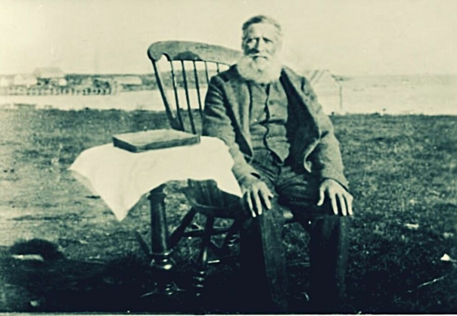 Per Jørstad in the rocking chair in Tsypnavolok around 1930. He had been instrumental in founding the Norwegian village around 1870. The picture is taken at the tail end of the happy time for the Norwegian colonists. Ten years later not one Norwegian was left on the peninsula.