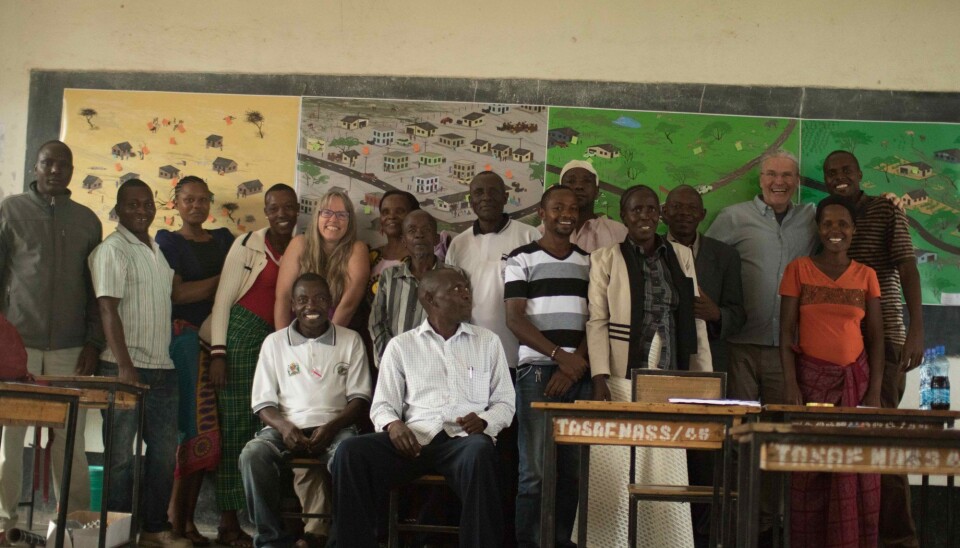 Participants stand in front of four posters showing possible future scenarios. The posters were used to encourage participants to discuss what they wanted for their own futures.