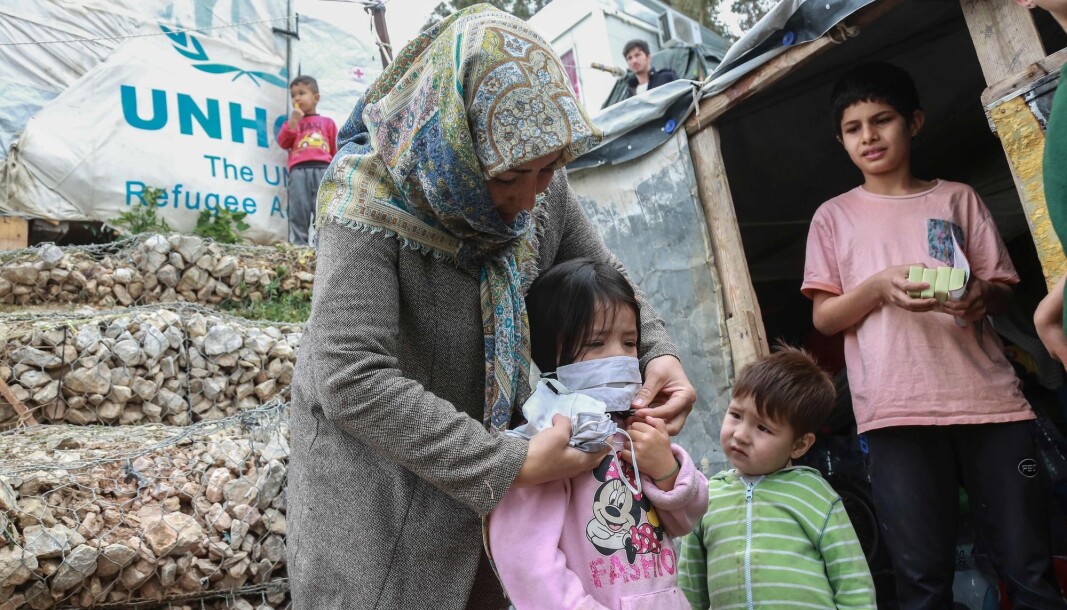 A woman helps a child with a mask after members of NGO "Team Humanity" gave out handmade protective face masks to migrants and refugees in the camp of Moria in the island of Lesbos on March 28, 2020 as as the country is under lockdown to stop the spread of Covid-19 disease caused by the novel coronavirus. A woman helps a child with a mask after members of NGO "Team Humanity" gave out handmade protective face masks to migrants and refugees in the camp of Moria in the island of Lesbos on March 28, 2020 as as the country is under lockdown to stop the spread of Covid-19 disease caused by the novel coronavirus.