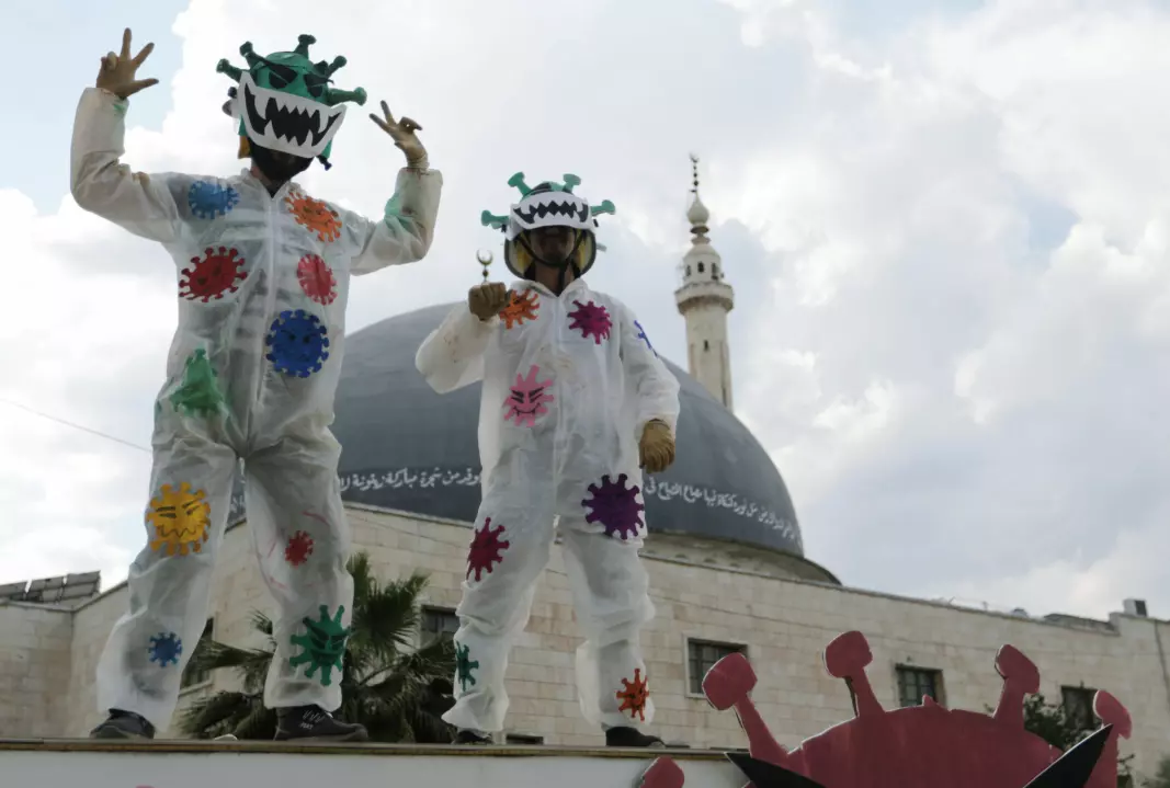 Volunteers dressed in coronavirus-themed costumes gesture as they stand on a vehicle during a campaign organised by the Violet Organization, in an effort to spread awareness and encourage safety amid coronavirus disease (COVID-19) fears, in the rebel-held Idlib city, Syria April 29, 2020.
