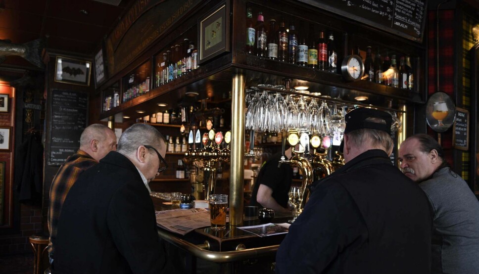 Men drinking beer in a bar in Stockholm 23 March this year. While Oslo's beer taps closed, restaurants and bars have stayed open in Sweden despite the coronavirus crisis.
