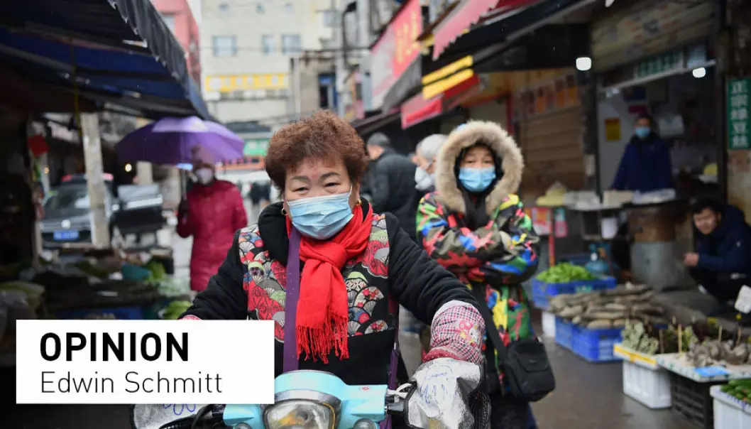 A woman wearing a facemask to help stop the spread of a deadly virus which began in the city rides her scooter through a market in Wuhan on January 24, 2020. Chinese people have since the start of the pandemic reported incidents of racism connected to the coronavirus and its origins all over the world, including in Norway.