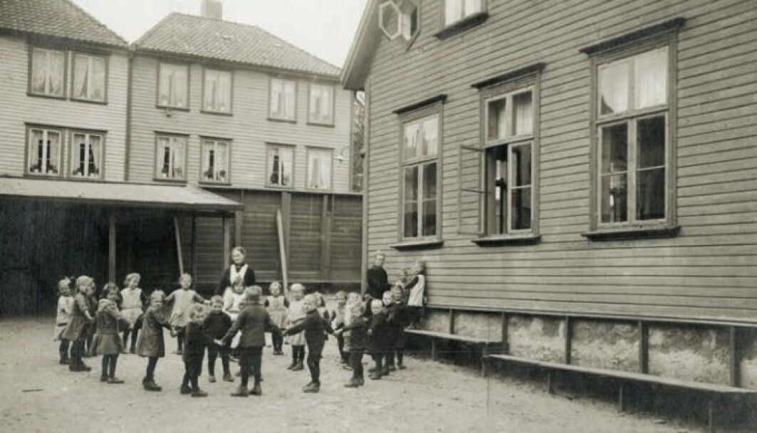 The Stavanger Cathedral childcare centre 1919: The courtyard is equipped with benches and a small half roof. “It looks like they're playing a circle game. But this is an arranged photo. I didn’t find anything in the written material describing it as a game with the children. This scene was enough to provide the photographer with a good image,” says Monika Röthle. The Stavanger Cathedral childcare centre 1919: The courtyard is equipped with benches and a small half roof. “It looks like they're playing a circle game. But this is an arranged photo. I didn’t find anything in the written material describing it as a game with the children. This scene was enough to provide the photographer with a good image,” says Monika Röthle.