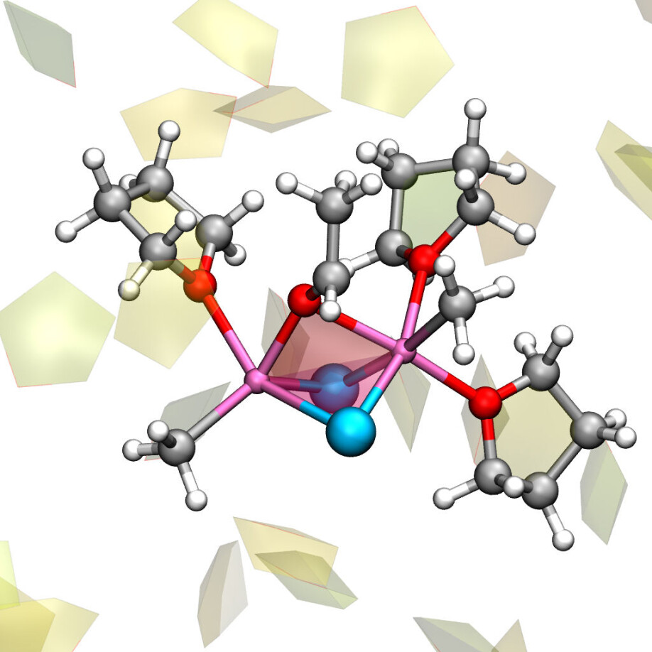 The reactive complex in the Grignard reaction involves two molecules from the Grignard reagent, which interact with acetaldehyde – CH3CHO – and three tetrahydrofuran molecules - (CH2)4O. Other solvent molecules are presented as pentagons in the background. Oxygen molecules are marked in red, magnesium is pink, chlorine is blue, carbon is black, and hydrogen atoms are white.