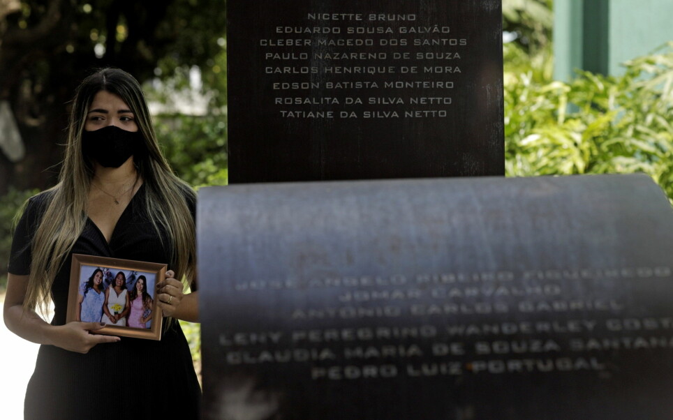 Thamires da Silva Netto, 29, who lost five relatives to the coronavirus disease (COVID-19), poses next to the 'Infinity Memorial' for COVID-19 victims, where the name of her mother and sister were written, at the Penitencia cemetery in Rio de Janeiro, Brazil.