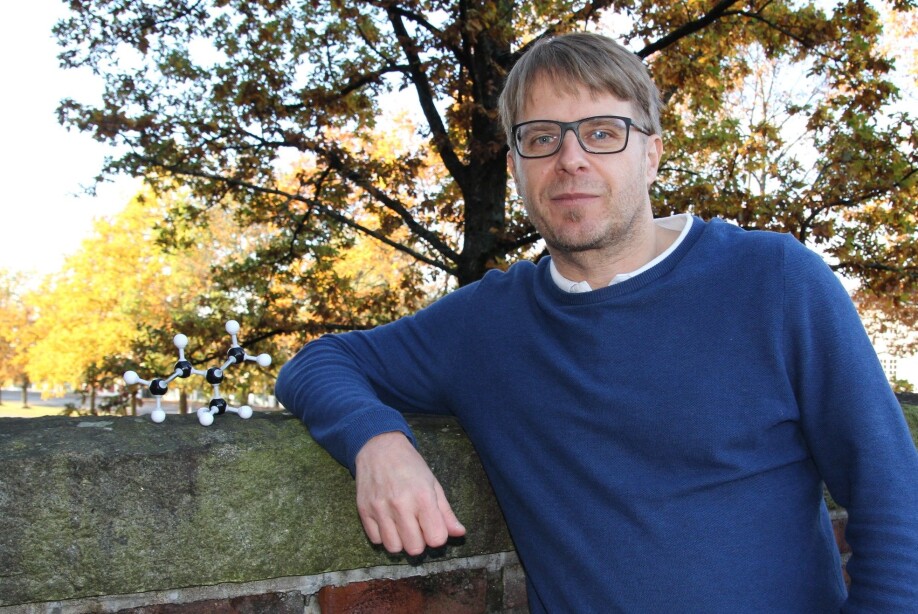 Professor Armin Wisthaler with an isoprene-producing oak tree in the background. To the left a model of the isoprene molecule.