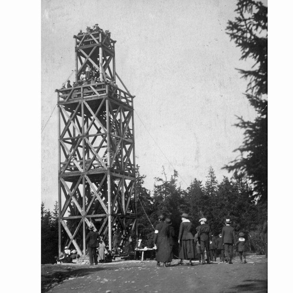 Tryvannstårnet tower was a popular destination for hikes as early as 1863, when the first observation tower was built by Thomas Heftye. The photograph shows the second tower, ca. 1920.