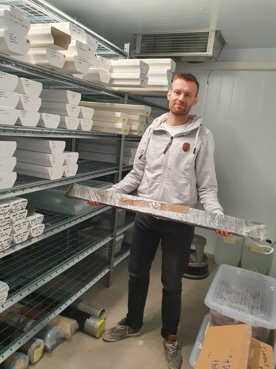 Youri Lammers holding a section from the sediment core in the storage at the Tromsø University Museum.