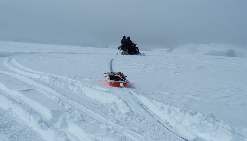A snowmobile towing georadar equipment.