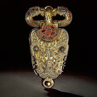Half human, half wild boar. Eagle heads are seen on each side of the man's face, and two eagles form the belt itself. Belt buckle from Åker in Hedmark. Half human, half wild boar. Eagle heads are seen on each side of the man's face, and two eagles form the belt itself. Belt buckle from Åker in Hedmark.