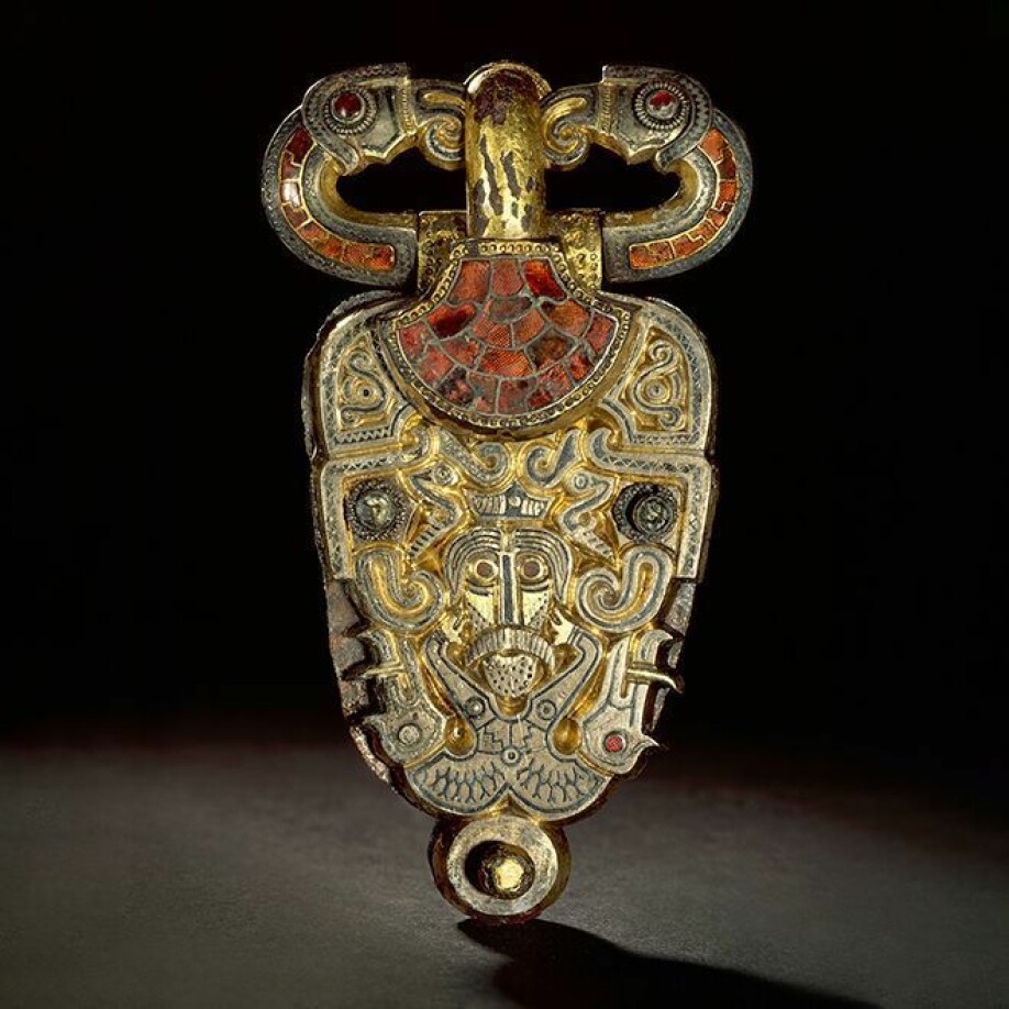 Half human, half wild boar. Eagle heads are seen on each side of the man's face, and two eagles form the belt itself. Belt buckle from Åker in Hedmark.