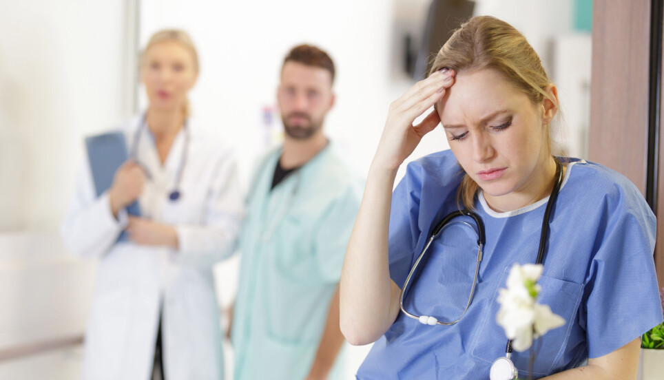 A health worker looks stressed and contemplative.