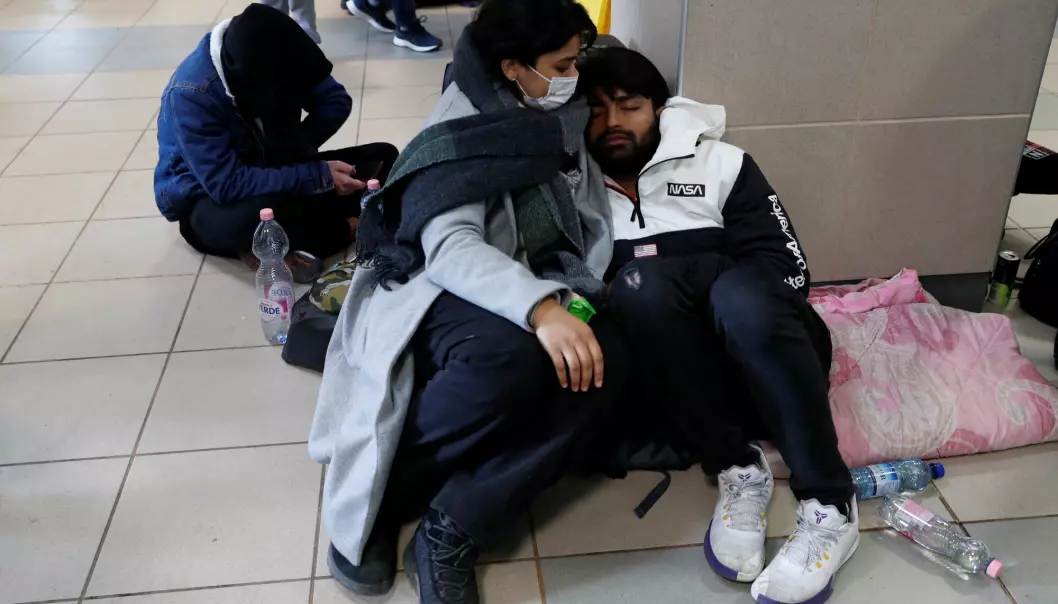 Indian students rest on the floor at the train station after fleeing Russia's invasion of Ukraine, in Zahony, Hungary.