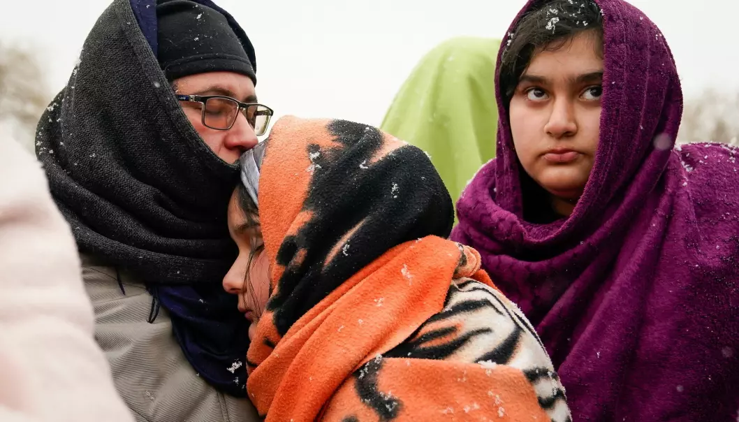 An Afghan family, who once fled the war in Afghanistan, wait to board a bus bound for a refugee centre, after fleeing the Russian invasion in Ukraine, in Medyka, Poland.