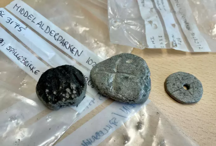 Three soapstone gaming-pieces. Or two soapstone gaming-pieces and a spindle whorl. More comparisons to previous finds may be needed in order to settle the question.