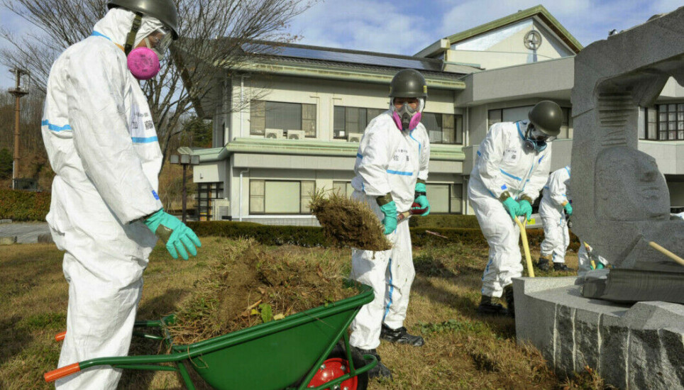 Members of the Self-Defense Force in Japan removing the top layer of soil and vegetation that has been contaminated by radioactive fallout from the accident at the Fukushima nuclear power plant. They have full protective equipment to prevent radioactive particles from entering the body. The photo was taken in 2011.