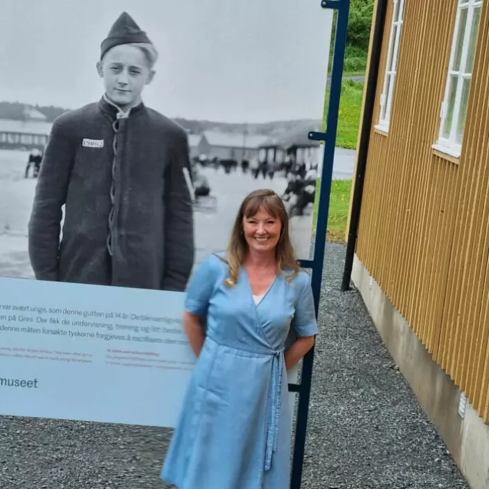 Camilla Maartmann is the lead curator at the Grini Museum. She is responsible for collecting objects and documents.Here she is standing by a picture of the youngest prisoner at Grini. He was only 14 years old.
