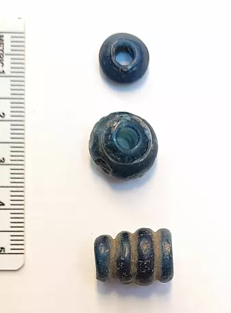 Three blue glass beads are several hundred years older than the rest of the find.