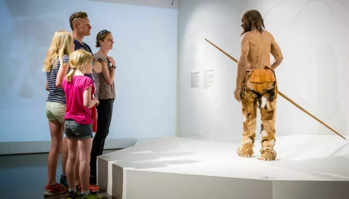 A family attends the reconstruction of Ötzi at the Bolzano Museum.