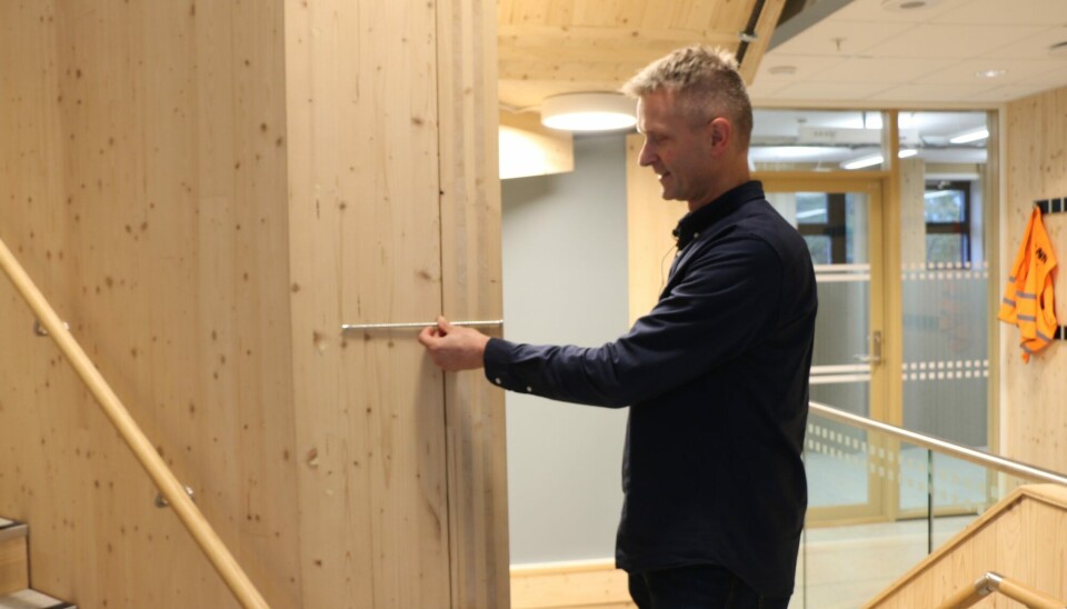 Tore Kvande holds one of the 30 centimetre long screws that were used to hold columns and beams together in the ZEB Lab. The use of clever design and the screws cut the use of steel in the building to a minimum.