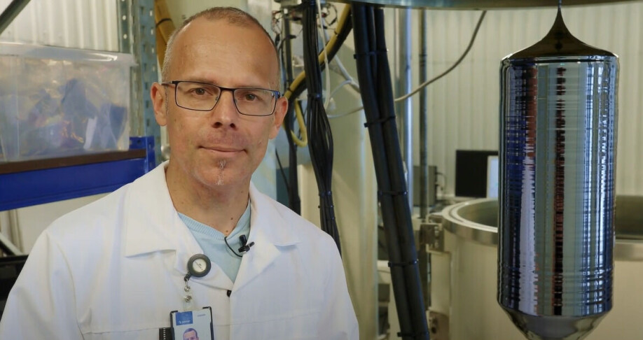 Martin Bellmann next to a silicon crystal called an ‘ingot’. This is the raw material for making solar panels.