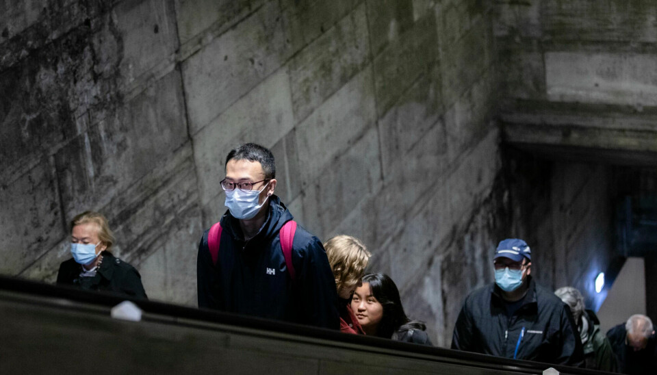 People on an escalator wearing masks.