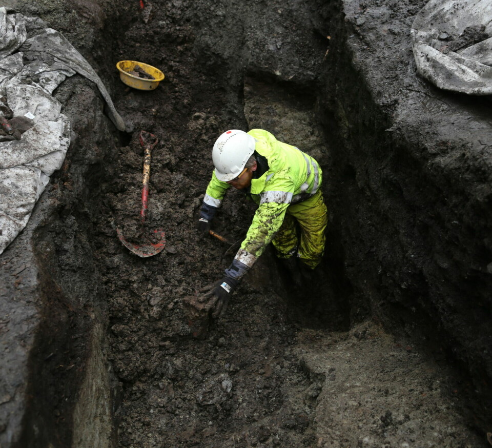 Archaeologist Dag-Øyvind Engtrø Solem hard at work in the pit where the gaming piece was found, about 4 metres below today's surface level.