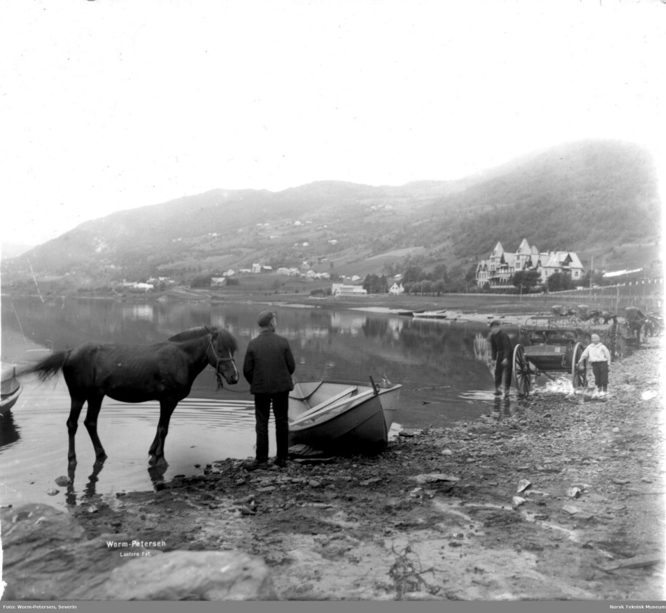 Vossevangen, hester og skysskarer ved Vangsvatnet, Fleischers hotell i bakgrunnen.