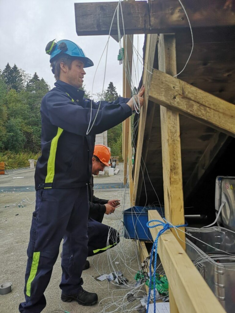 Researcher Reidar Stølen (left) and master’s student Joacim Skogseide install temperature measuring points at different positions on the roof before lighting the fire.