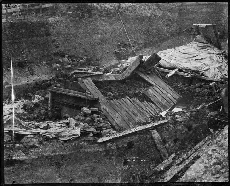 Oseberg ship during excavation. Here you see the burial chamber on top of the ship. You can also clearly see the layer of stones in front of the chamber.
