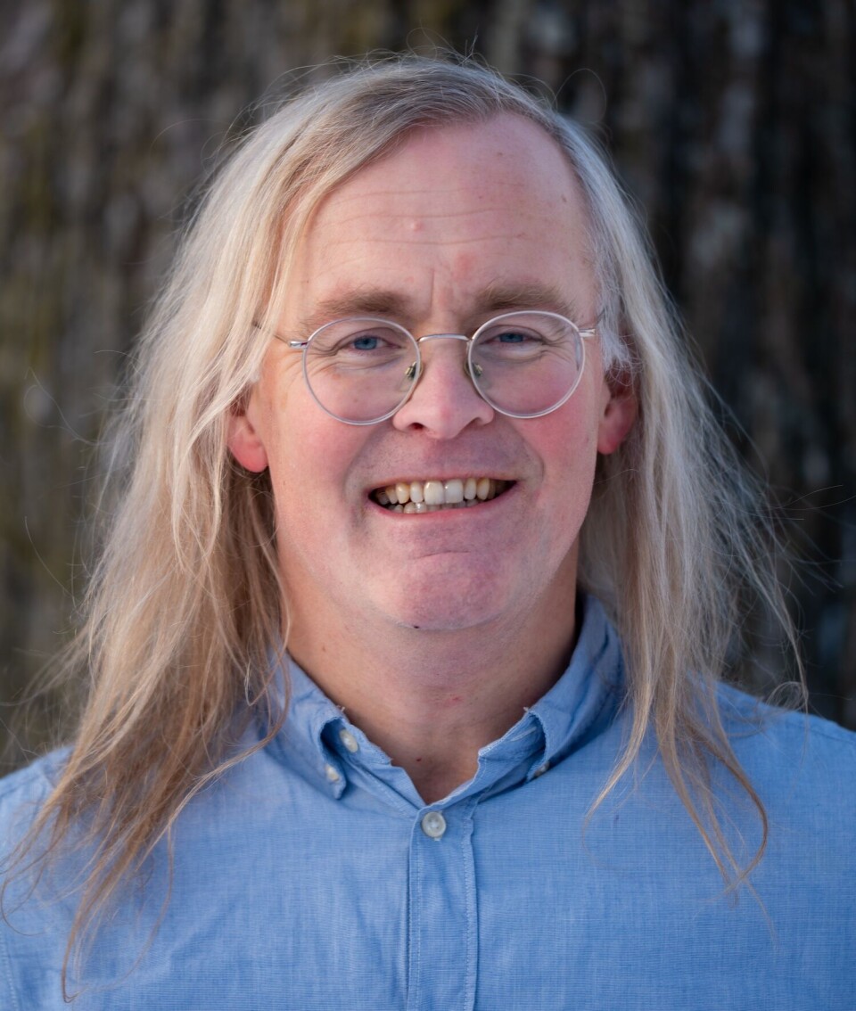 'I am curious about how citizen councils can supplement democratic elections,' philosopher Odin Lysaker says. Portrait of a man with long blonde hair, round glasses, in a blue shirt.