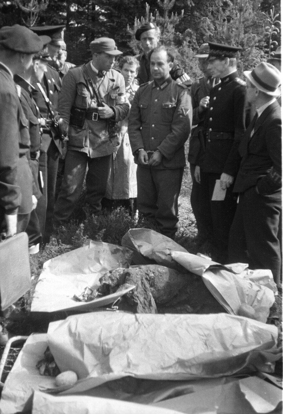Oskar Hans (in the middle, handcuffed) showed where the graves were located. He also had to watch the exhumation of the bodies.