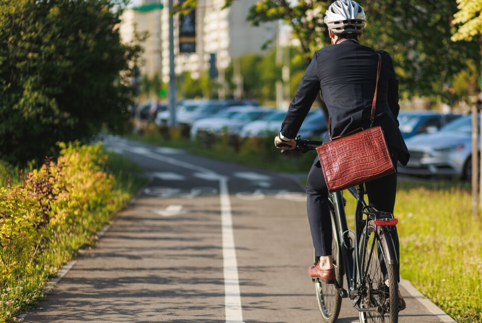 Limited car parking in central city areas and lowered speed limits have made Oslo a more bicycle-friendly city. Mann i dress på sykkel