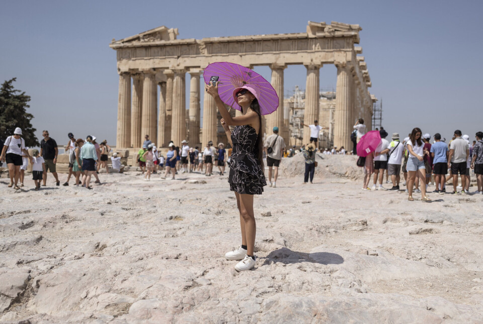 A woman takes a selfie in front of the Parthenon temple on the Acropolis in Athens in July 2023.