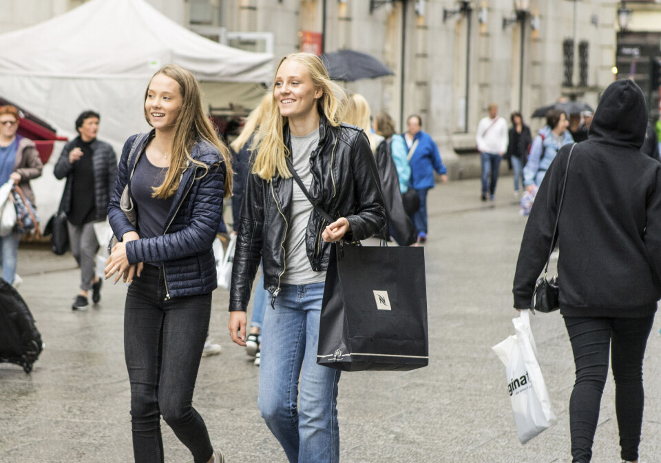 More responsibility for personal finances can prepare adolescents for adulthood. To jenter i tenårene i handlegate med handlepose.
