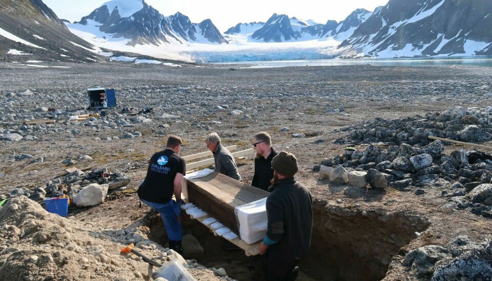 The coffin is lifted out of the grave before transport to Longyearbyen.
