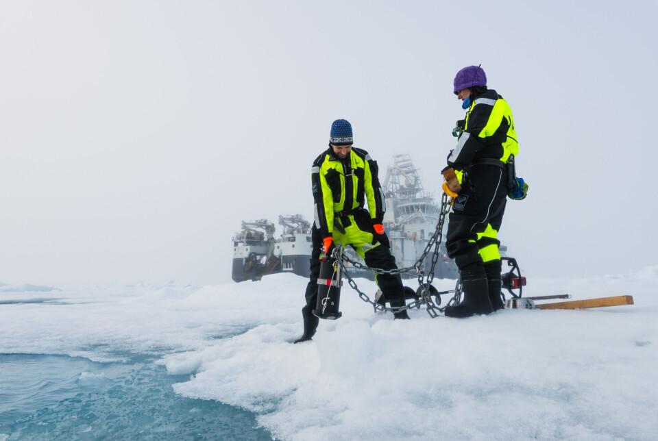 Climate scientist Morven Muilwijk (left) is deploying an instrument to measure the strength and direction of ocean currents at various depths while it hangs under the ice. Here with colleague Zoe Koenig.