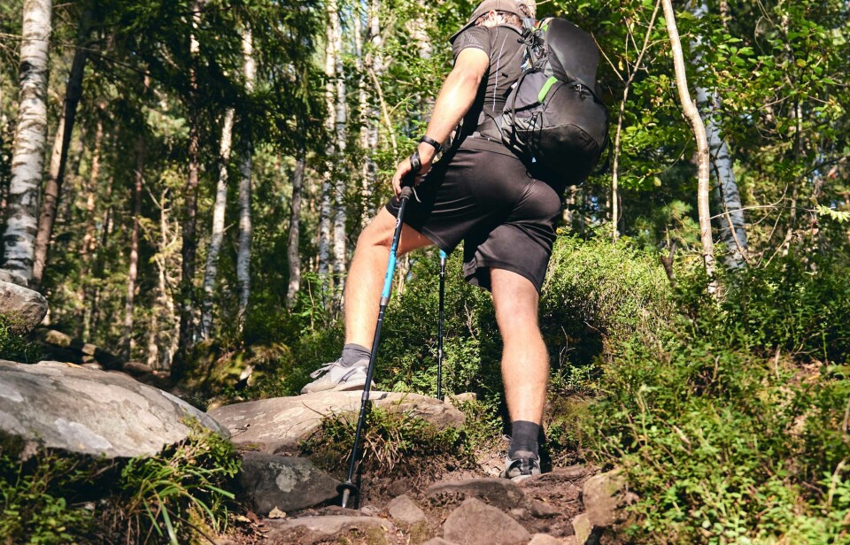 Adults need to motivate themselves a little extra to maintain good exercise habits. A man in black workout clothes on a hiking trail.
