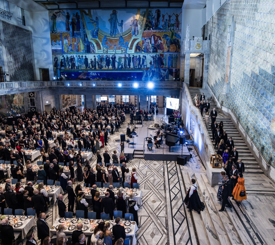 The prize winners are accompanied down the stairs and welcomed by the guests of the banquet.