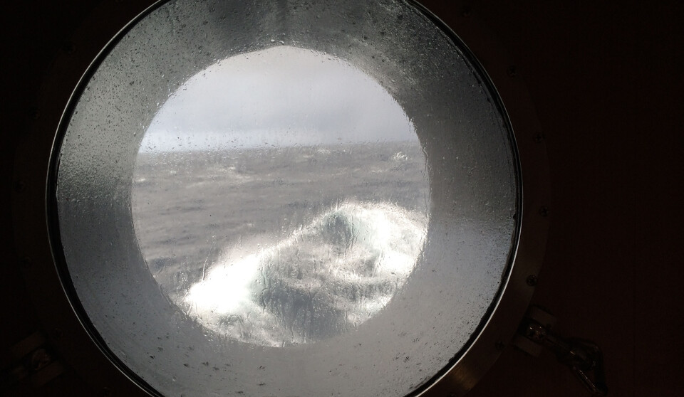 Waves strike the porthole, but no one can see what moves beneath the surface.